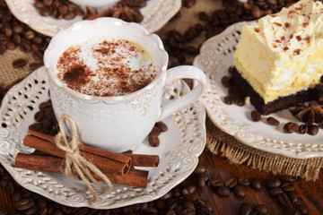 coffee with foam and cocoa and vanilla chocolate cake and bag of coffee beans