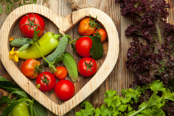 Set of different fresh raw colorful vegetables near the wooden tray, light background