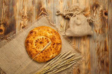 Naan bread on a wooden table. Top view. Fresh fragrant crispy bread. Tandoor bread on cutting board closeup. Home-made bread on an old background. Orient cuisine.