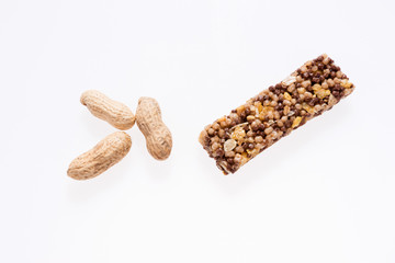 Two healthy granola bar (muesli or cereal bar) and peanuts isolated on white background