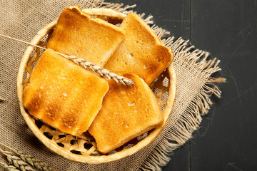 Toast the bread on a black wooden background