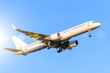 White passenger airplane landing at airport in the blue sky