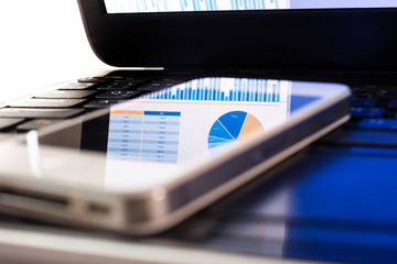 Blur of reflect business graph on smartphone.Analysis/financial concept