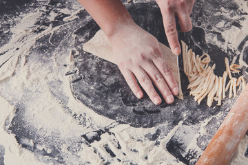 Cooking noodles concept on black background, sprinkled flour wit