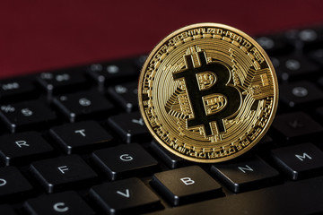Close up of a Bitcoin replica near the letter B on a keyboard