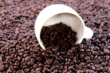 A cup of white coffee is on the coffee beans.