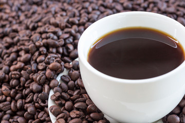 Hot coffee in white cup and coffee beans