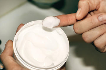 Skin care: cream jar in girls hand