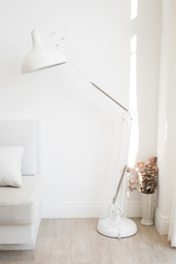 Interior living room / bedroom design in minimal modern white style with white standing lamp and sofa bed and curtain opened for sunlight.