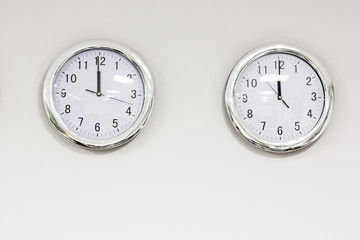 Modern quarz analog clocks on white wall in office