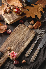 Decoration Helluin. Autumn card. Chestnuts on a wooden board, wood, leaves and nuts. free space text.