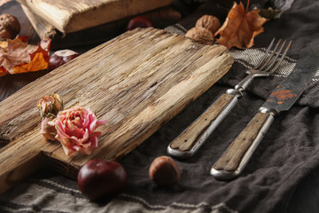 Decoration Helluin. Autumn card. Chestnuts on a wooden board, wood, leaves and nuts. free space text.