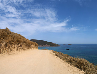 Corsica, 28/08/2017: la strada sterrata che porta alla spiaggia di Tamarone, una delle più famose e selvagge del Cap Corse, circondata dalla macchia mediterranea