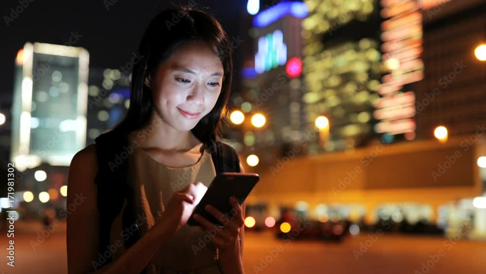 Wall mural young woman use of smart phone at night