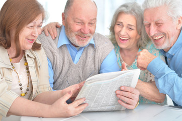 senior couples reading newspaper