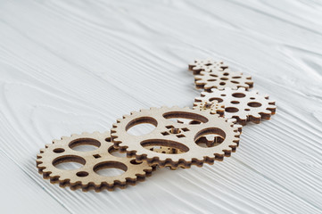 Gear wheels on white wooden background. The concept of creative, logical thinking.