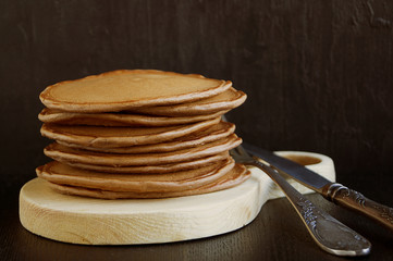 A stack of chocolate pancakes on a black background.