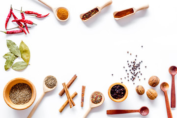 Kitchen table with spices and dry herbs on white kitchen background top view mock up