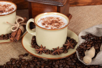 coffee with milk and chocolate foam in brown ceramic cups with vanilla and coffee grains
