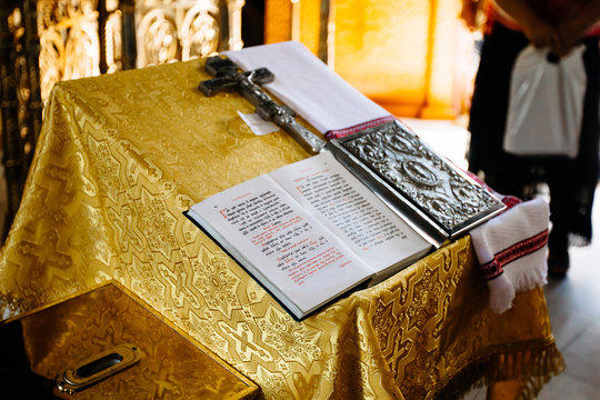 sacred lectern in the church decorated with golden friezes and ornaments, church interior with bible on reading-desk or lectern