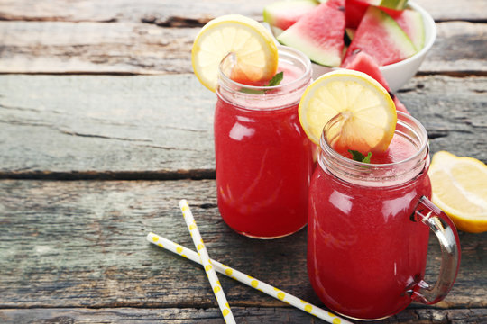Watermelon smoothie in glass jars on wooden table