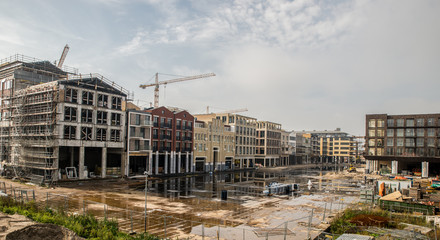 Construction site with houses and steel cranes
