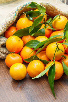 fresh mandarin oranges fruit with leaves on wooden table