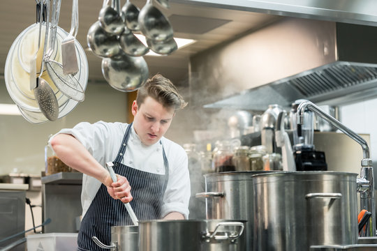 Portrait of a dedicated young head chef cooking in the commercial kitchen of a hotel