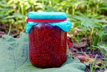 красное малиновое варенье в стеклянной банке в...