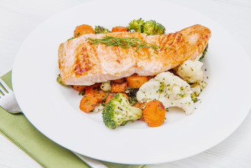 salmon fillet on a bed of broccoli, cauliflower and carrots