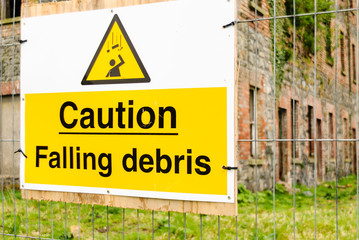 Sign on fence stating "Caution Falling Debris"