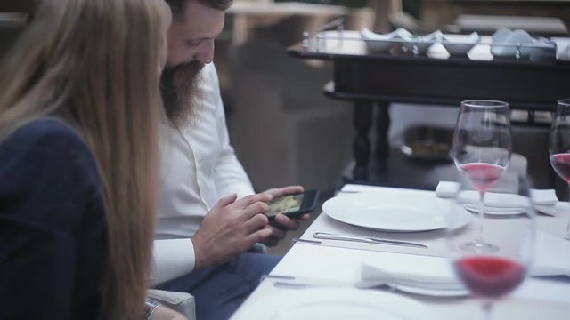 Young couple using smartphone in cafe