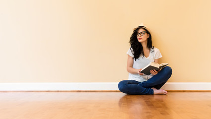Fototapeta na wymiar Young woman reading a book in a big room