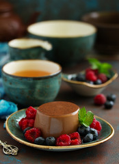 Delicious home-made chocolate dessert Panna cotta. Cream-caramel, caramel custard, with raspberries and blueberries.