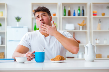 Man falling asleep during his breakfast after overtime work