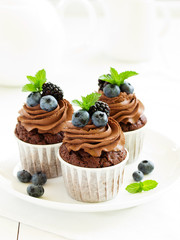 Chocolate cupcakes, with chocolate cream and fresh berries.