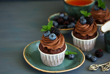 Chocolate cupcakes, with chocolate cream and fresh berries.