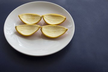 Orange cut in to slices on the white plate eaten.Peel