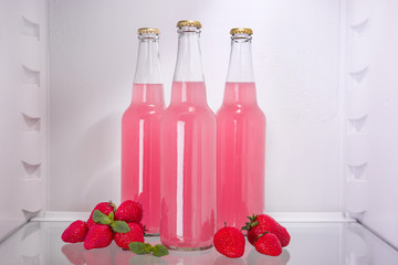 Bottles of fresh strawberry lemonade in fridge
