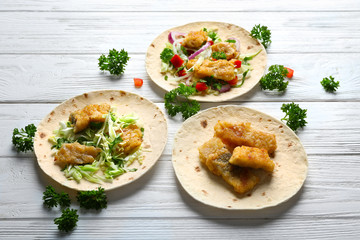 Tasty fish tacos on wooden table