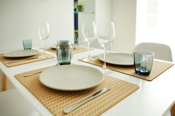 Interior of light modern dining room with served table
