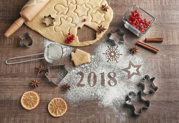 Dough for Christmas cookies and 2018 made with flour on wooden table