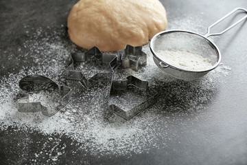 Composition with dough and cutters for Christmas cookies on table