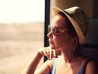 Young attractive woman looking into the window while travelling by train.