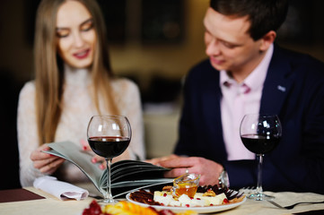 guy with a girl in a restaurant choose dishes from the menu