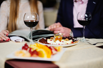 guy with a girl in a restaurant choose dishes from the menu