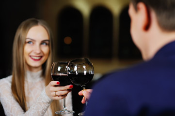 a man with a woman drinking red wine in a restaurant