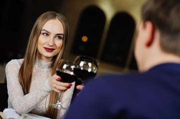 a man with a woman drinking red wine in a restaurant