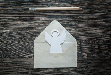 Vintage envelope angel pencil on black board top view