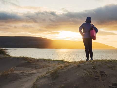 A woman watching sunset on West Coast of Ireland.